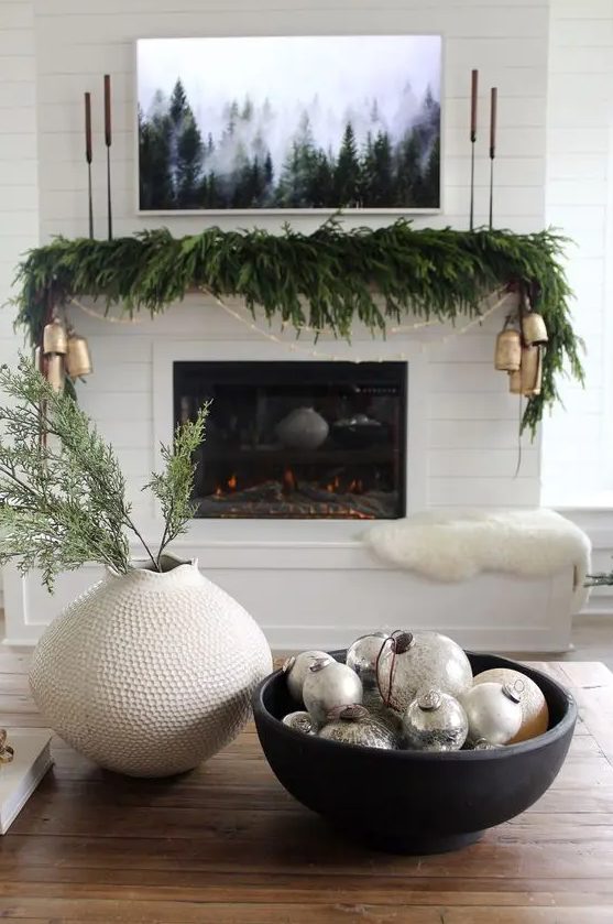 a modern Christmas centerpiece of a black bowl with mercury glass ornaments is a stylish idea for the space