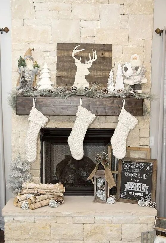 a pine garland with snowy pinecones, a pallet deer sign, Santa Claus dolls and white stockings