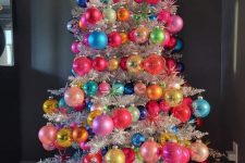 a silver tinsel Christmas tree with colorful oversized ornamnets is a fantastic color statement for any space