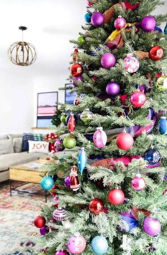 a super bold and chic modern Christmas tree decorated with colorful ornaments of various shapes