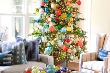 a tall Christmas tree covered with lights and lots of colorful ornaments of various shapes and sizes