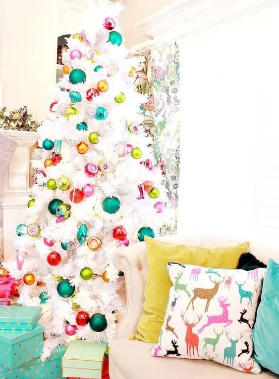 a white Christmas tree decorated with colorful ornaments is a fun and bold decor idea that rocks