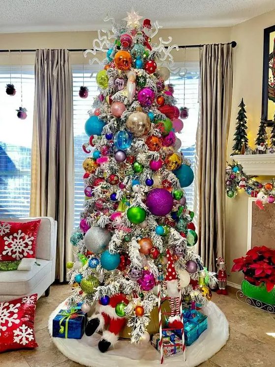 a white Christmas tree with extra bold oversized and usual ornaments is a funky and unusual solution