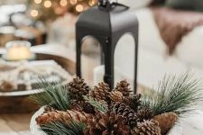 a woodland Christmas decoration of a bowl filled with evergreens and pinecones is a cool centerpiece idea