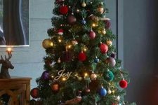 an adorable Christmas tree styled with lights and jewel tone and metallic ornaments, a star topper and calligraphy