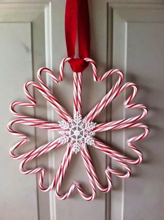 a candy cane wreath with snowflakes and red ribbon
