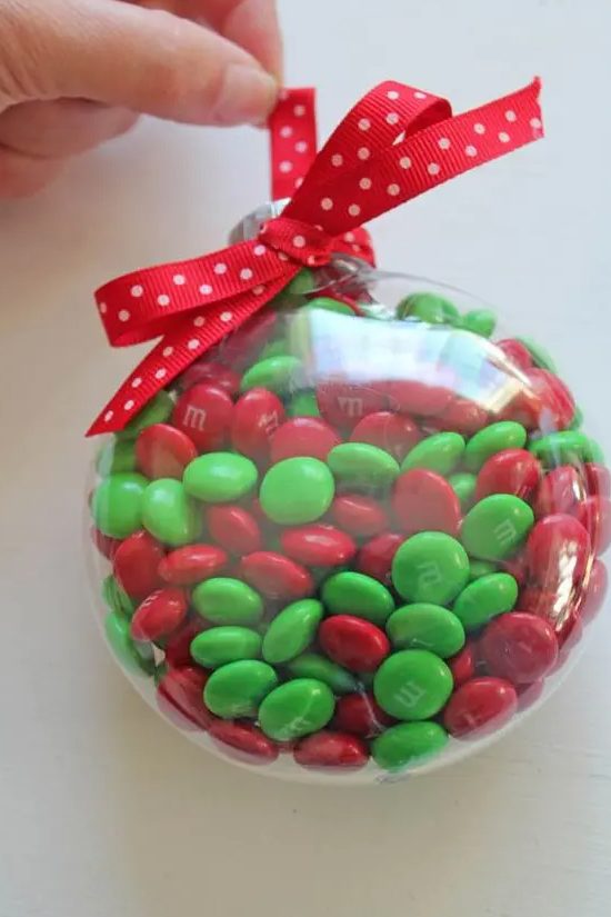M&Ms fill ornament with a red bow is a lovely Christmassy idea in traditional colors, and it's very easy to make