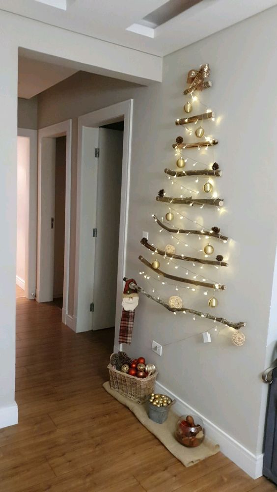 a classy and easy wall-mounted Christmas tree of branches and lights plus elegant Christmas ornaments is cool