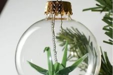 a clear Christmas ornament with a green paper crane is a cool idea as cranes in origami symbolize happiness