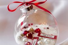 a clear Christmas ornament with faux snow, pearls and rhinestones and a date is a cool and fun decor idea