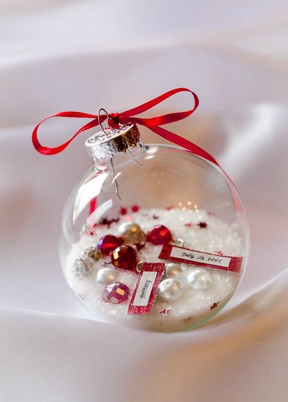 a clear Christmas ornament with faux snow, pearls and rhinestones and a date is a cool and fun decor idea
