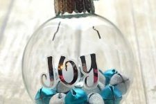 a clear glass Christmas ornament with letters, white glitter and blue bells is a fun and cool way to add color to your Christmas tree