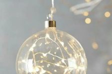 a clear glass Christmas ornament with lights is a cool idea – such decor will make your tree sparkle