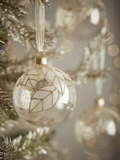 a clear glass Christmas ornament with white leaves and gold glitter accents are amazing for the holidays