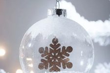 a frosty glass Christmas ornament with faux snow inside and a touch of frost on top plus a gold snowflake