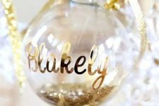a glitter filled ornament with a name and a bow will be a perfect Christmas gift tag that you can easily make yourself