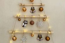 a hanging Christmas tree with branches and yarn, with lights, ornaments and snowflakes is lovely