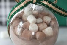 a hot cocoa Christmas ornament topped with a green and gold ribbon bow is a cool gift and decoration for the holidays