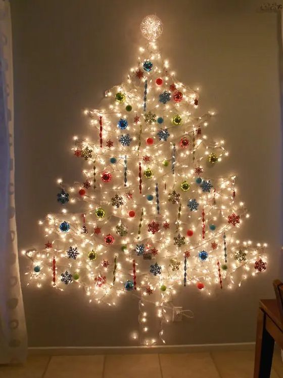 a large Christmas tree on the wlal done of lights and with colorful ornaments all over