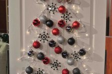 a lovely Christmas wall-mounted tree of lights, grey, graphite grey and red ornaments is amazing