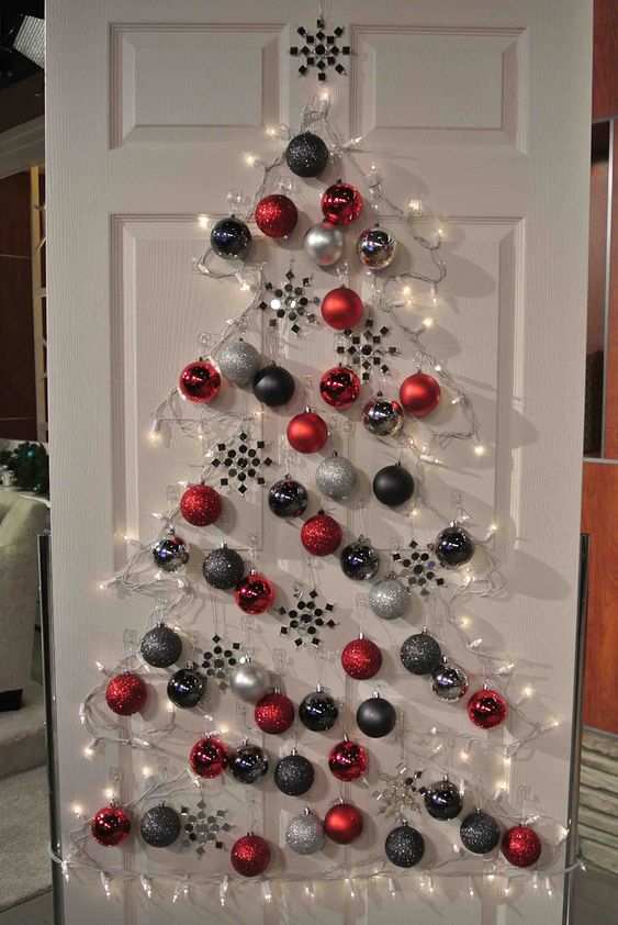 a lovely Christmas wall-mounted tree of lights, grey, graphite grey and red ornaments is amazing