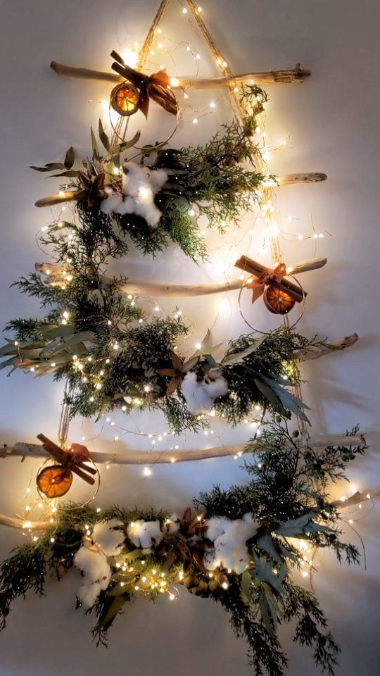 a messy all-natural Christmas tree of branches, evergreens, cotton, dried citrus, cinnamon and lights