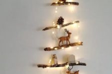 a mini Christmas tree made of branches, lights and decorated with pinecones and little animal figurines