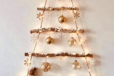 a shiny wall-mounted Christmas tree of bbranches with twine, with snowflakes and shiny ornaments plus a star topper