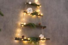 a small and cool wall Christmas tree of a couple of branches and lights, evergreens, cotton and a star topper is cool