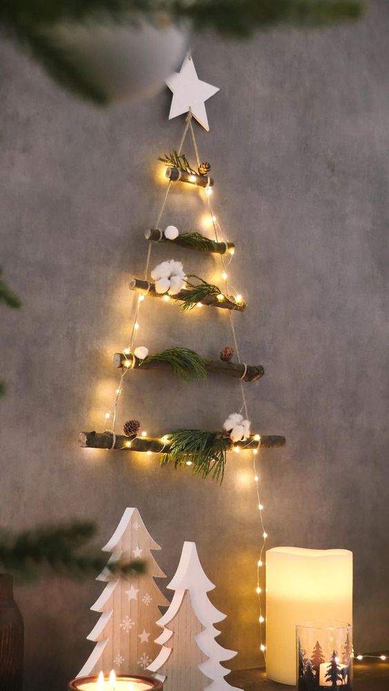 a small and cool wall Christmas tree of a couple of branches and lights, evergreens, cotton and a star topper is cool