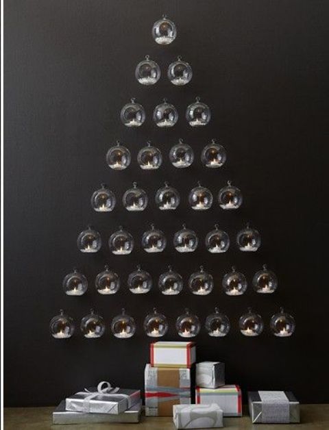 A unique wall mounted Christmas tree of clear baubles that are candleholders is an ultra modern solution