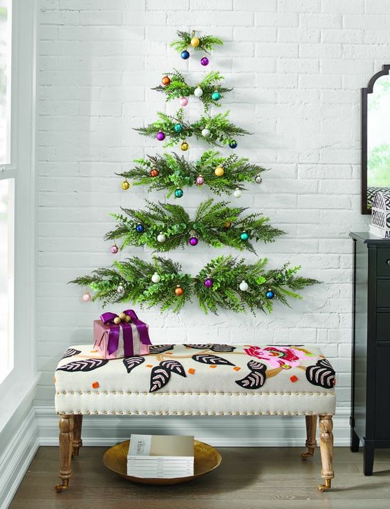 a wall-hanging Christmas tree of greenery and colorful ornaments is a nice fit for any space with some color
