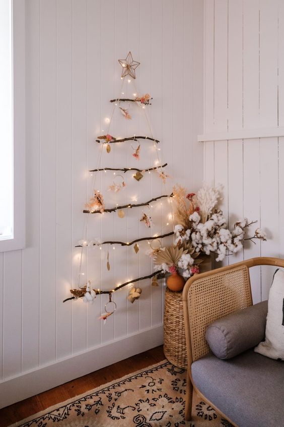 an easy and messy wall-mounted Christmas tree of branches, lights, cotton, leaves and other stuff
