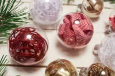 clear Christmas ornaments filled with red and gold ribbons and yarn look bright, fun and awesome
