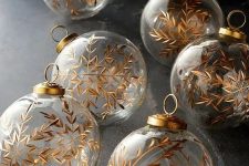 clear glass Christmas ornamens decorated with gold snowflakes look magical and will bring this magical touch to your tree