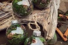 clear glass Christmas ornaments filled with moss, greenery, pinecones and cinnamon bark are amazing for woodland or rustic holiday decor