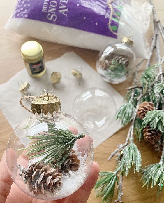 clear glass ornaments filled with faux snow, evergreens and pinecones are great Christmas ornaments