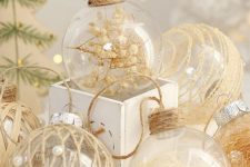clear glass ornaments filled with feathers and baby’s breath and wrapped with twine look very cool