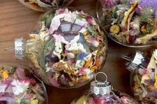 clear glass ornaments with dried flowers are lovely boho Christmas decorations or party favors