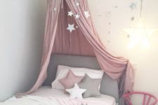 18 a grey bed with a pink star canopy and star garlands all over