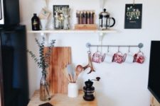 19 small drink station with hanging mugs, a tine table and a couple of shelves
