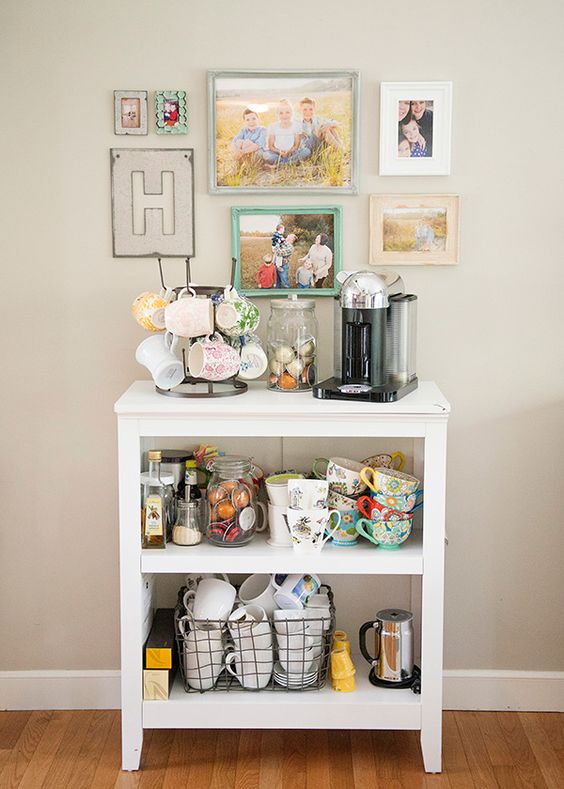 cozy coffee station with a lot of colorful mugs and family pictures on the wall