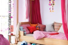 24 a wooden bed with colorful textiles and bold pink drapes