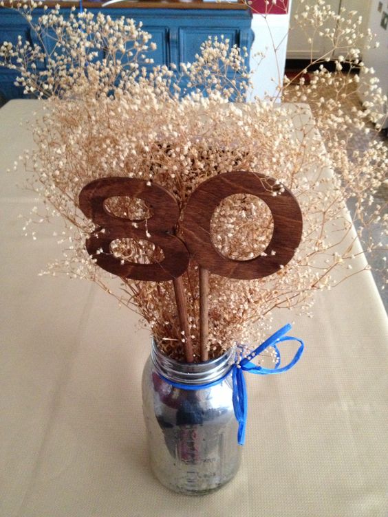 80th birthday centerpiece with wooden numbers and ribbon