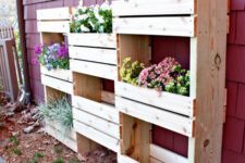 16 vertical planter built of various crates and pallets to accomodate a lot fo greenery and flowers
