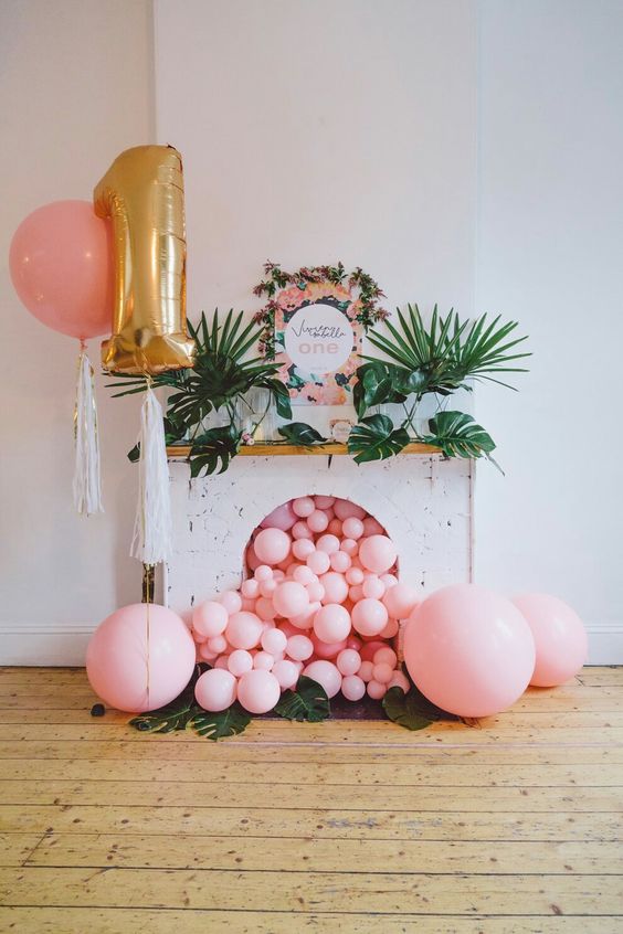 pink balloons falling from a faux fireplace