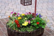20 an old barrel turned intoa  garden bed with a light