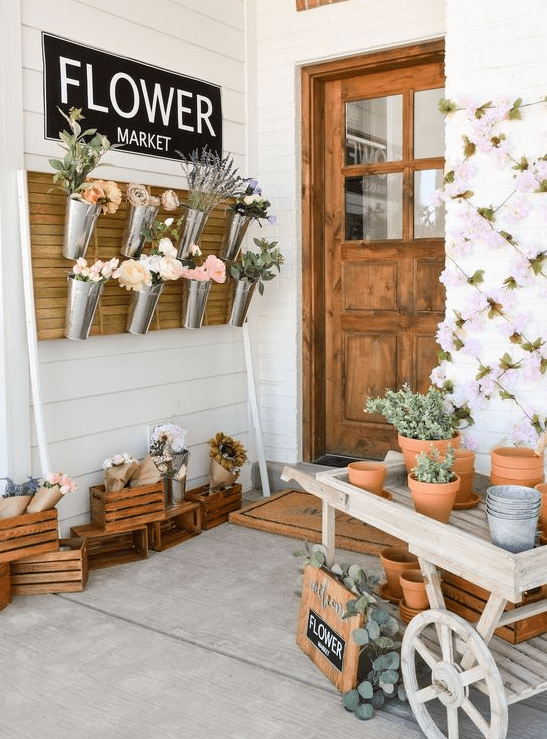 a fun idea to turn your porch into a flower market hanging blooms in buckets and placing them everywhere