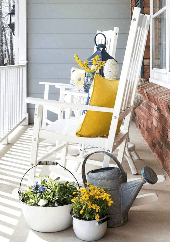 potted blooms, a watering can, bright blooms, colorful pillows for a bright and fun spring porch