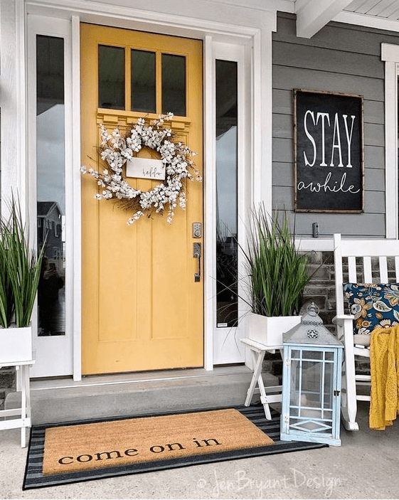 potted grass, a faux bloom wreath and a chalkboard sign for a bright and fun porch